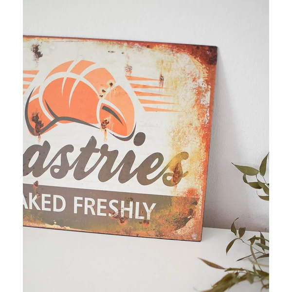 Vintage stílusú fémtábla „Pastries – Baked freshly” felirattal, croissant grafikával